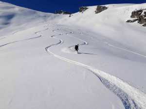 Ski mountaineer navigating fresh snow in New Zealand's alpine terrain.