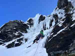 Ice climbing at Wye Creek in Wanaka, New Zealand, with climber ascending frozen waterfalls.